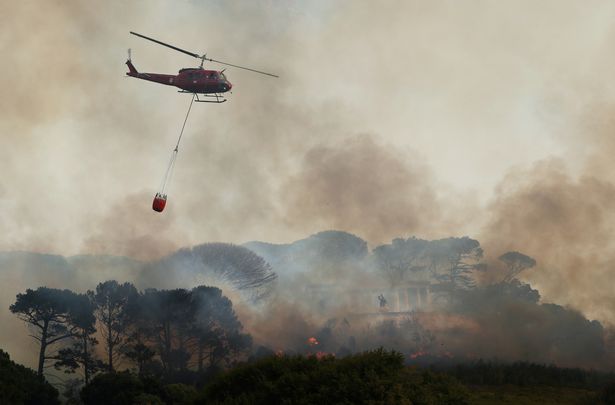 Firefighters battle to contain a bushfire that broke out on the slopes of Table Mountain