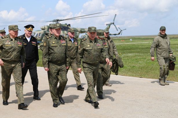 Russian Defence Minister Sergey Shoigu (C) and Chief of the Russian General Staff Valery Gerasimov (C-L) inspecting Russian military drills at the Opuk training ground