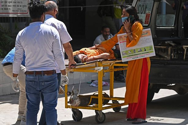 A family carry their relative on a stretcher outside a Delhi hospital