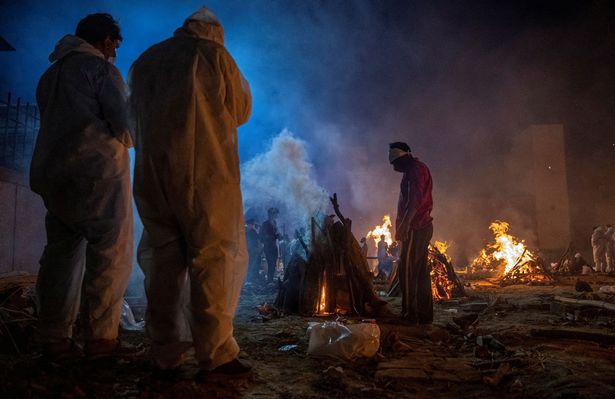 Devastating photos show people cremating bodies in the streets of Delhi in India