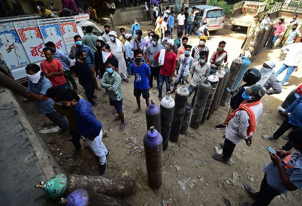 People wait to refill their medical oxygen cylinders for Covid-19 coronavirus patients in Allahabad, India