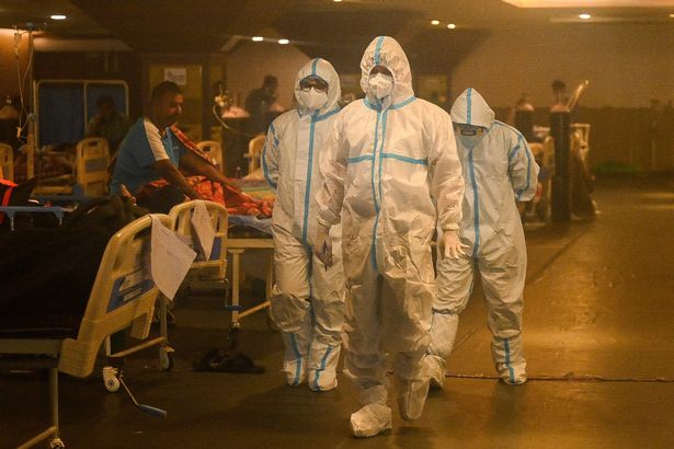 Health workers tend coronavirus positive patients inside a banquet hall temporarily converted into a care centre in New Delhi