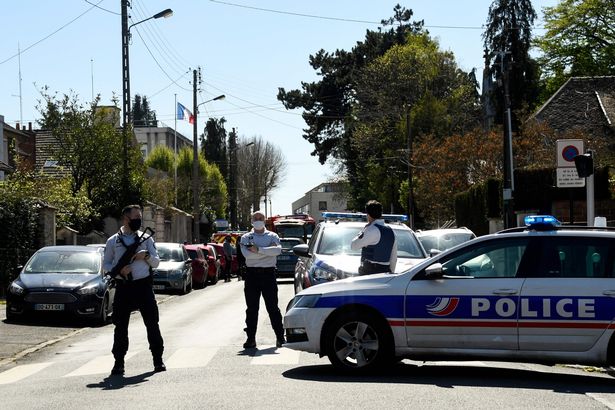 French police officials stand near a police station in Rambouillet after an officer was stabbed to death