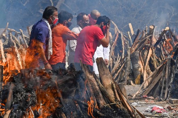 A man reacts as he performs the last rites of his relative