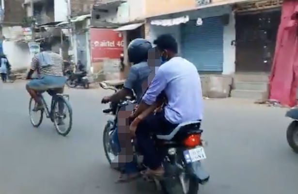 The men carry the woman between them, who has been named locally as 50-year-old G Chenchu of Killoyi, Andhra Pradesh