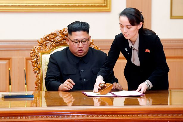 North Korean leader Kim Jong-un signs a document with help from his sister Kim Yo-jong