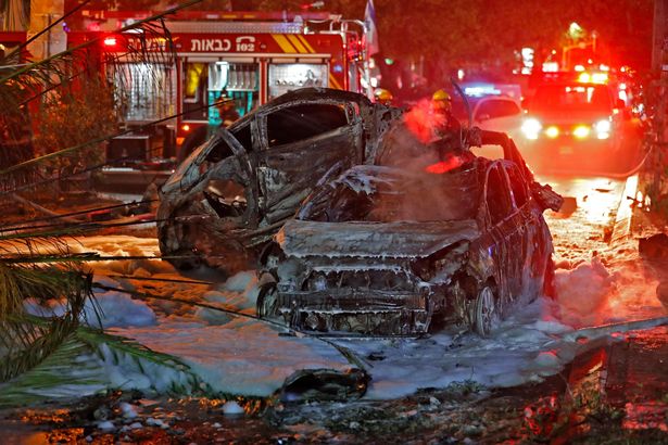 Burnt cars are seen in the Israeli town of Holon near Tel Aviv after rockets are launched towards Israel from the Gaza Strip