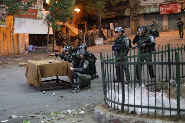 Israeli forces intervene in Palestinians during a protest against attacks by Israeli police with tear gas, rubber bullets and stun grenades on Palestinians at Masjid al-Aqsa, in Hebron, West Bank on May 12, 2021