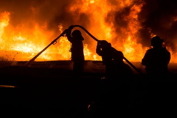 Israeli firefighters battle a field fire after a rocket launched from Gaza strip