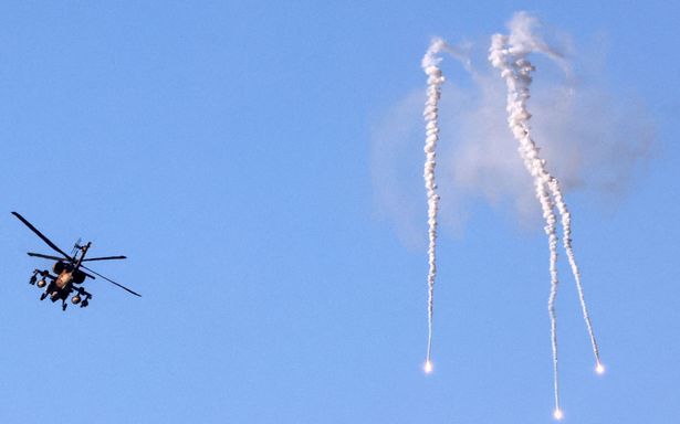 An Israeli AH-64 Apache attack helicopter releases flares near Sderot