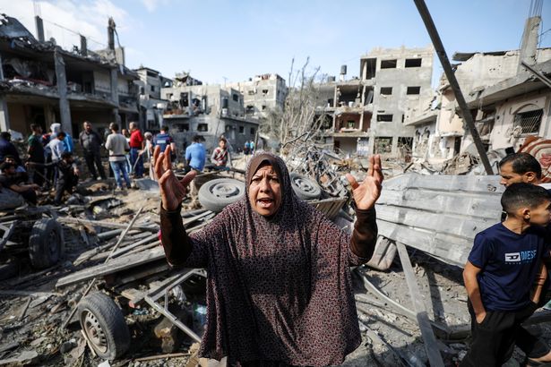 A Palestinian woman reacts as she and Palestinians search their belongings while rescue efforts continue to evacuate Palestinians from the rubble of the buildings destroyed by ongoing Israeli airstrikes on Gaza, in Beit Hanoun, Gaza on May 14, 2021