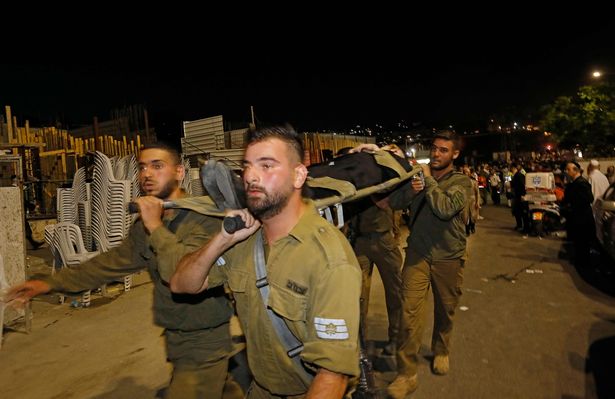 Members of the Israeli security forces evacuate an injured an ultra-Orthodox Jewish man after the collapse