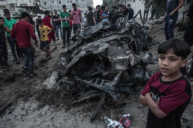 Palestinians inspect the effects of an Israeli attack on a car north of Gaza City on May 15