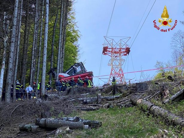 Firefighters gather after a cable car plunged to the ground near Stresa, Italy