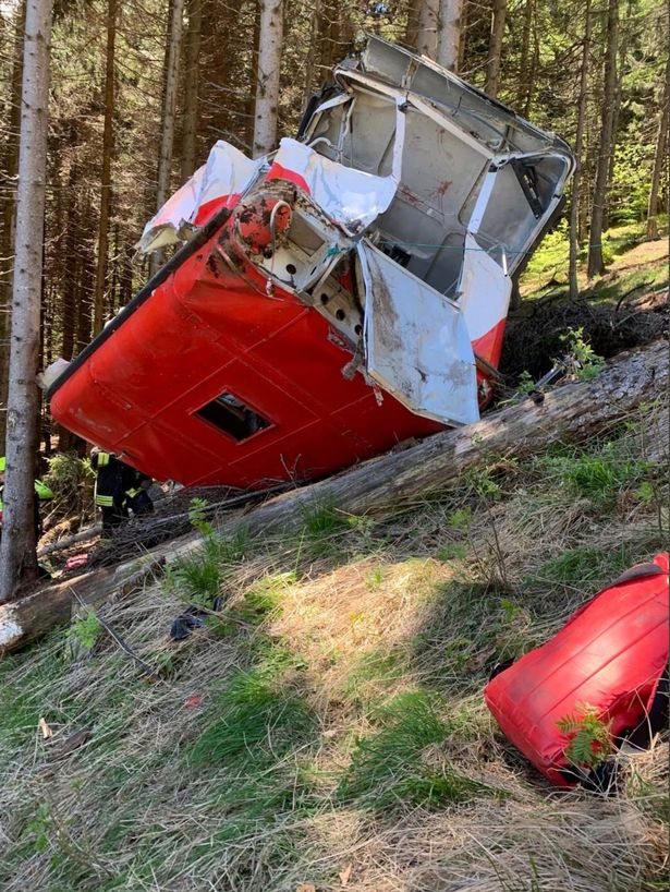 The wreckage of the red and white Stresa-Mottarone cable car lies in a crumpled heap on the mountainside