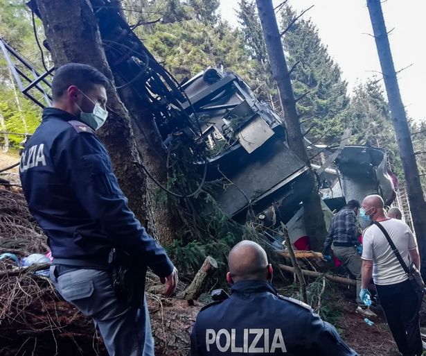 The Italian State Police and rescuers work at the crash site on the steep gradient