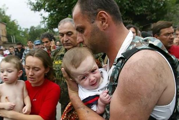 Elbrus Gogichaev carries baby Alyona Tskaeva out of school number 1 in Beslan - close up