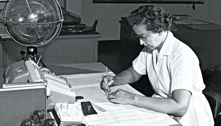 black and white photo of Katherine Johnson sitting at a desk