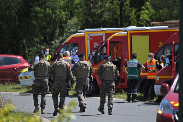 French soldiers walk past firefighters vehicles after a municipal policewoman was attacked with a knife on May 28, 2021