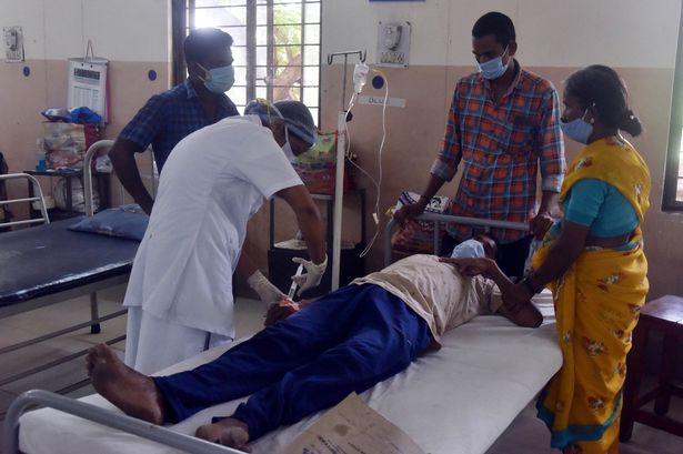 A medical worker treats a patient infected with mucormycosis, or black fungus, at a hospital in Koti, India.