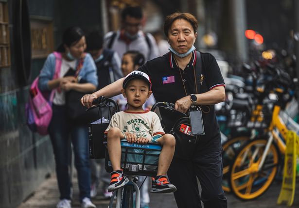 Parents take children home after school in Shanghai, China, 11 May 2021