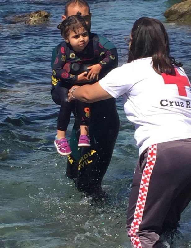 A toddler pictured being rescued from the sea