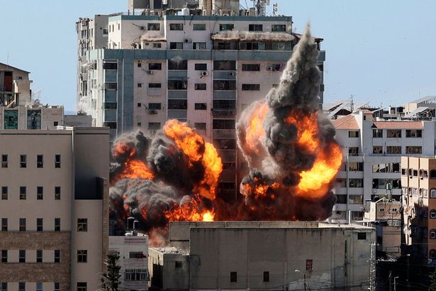 A ball of fire erupts from the Jala Tower as it is destroyed in an Israeli airstrike in Gaza city controlled by the Palestinian Hamas movement, on May 15, 2021. - Israeli air strikes pounded the Gaza Strip, killing 10 members of an extended family and demolishing a key media building, while Palestinian militants launched rockets in return amid violence in the West Bank. Israel's air force targeted the 13-floor Jala Tower housing Qatar-based Al-Jazeera television and the Associated Press news agency in the Gaza Strip. (Photo by MAHMUD HAMS / AFP) (Photo by MAHMUD HAMS/AFP via Getty Images)