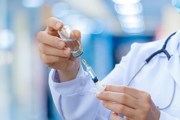 The doctor prepares the syringe with the cure for vaccination.