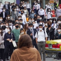 Commuters walk near Shinjuku Station in Tokyo on Monday. The capital reported new 260 cases of COVID-19 the same day.  | AFP-JIJI