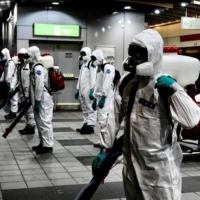 Soldiers from the chemical unit prepare to spray disinfectant in the Taipei subway system on Wednesday.  | AFP-JIJI