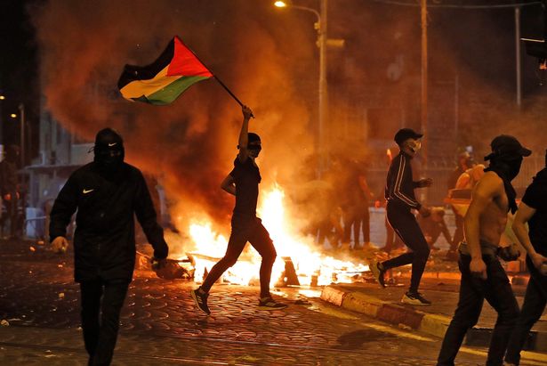 Palestinian protesters hurl stones during clashes with Israeli forces in the Shuafat camp for Palestinian refugees