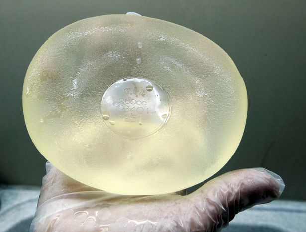 A nurse displays a cleaned defective silicone gel breast implant, manufactured by French company Poly Implant Prothese (PIP), after being removed from a patient in a clinic in Nice