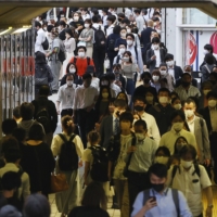 People walk in the Shinjuku district of Tokyo on Wednesday. | KYODO