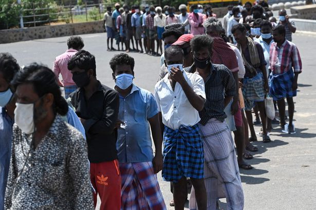 A queue for food distributed by volunteers of an NGO during a lockdown imposed in Tamil Nadu state in Chennai