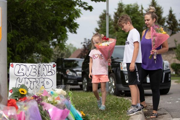 Mourners pay their respects to the Afzaal family at a memorial