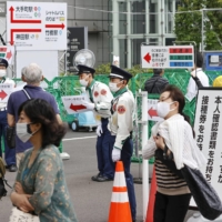 People aged 18 and older go to the mass vaccination center run by the Self-Defense Forces in Tokyo on Thursday. | KYODO