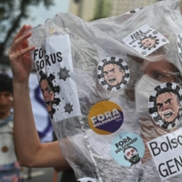 A demonstrator takes part in a protest against Brazilian President Jair Bolsonaro's handling of the COVID-19 pandemic, in Rio de Janeiro on Saturday. Brazil is also facing an election battle next year, with a resurgent left looking to unseat right-wing Bolsonaro. | AFP-JIJI