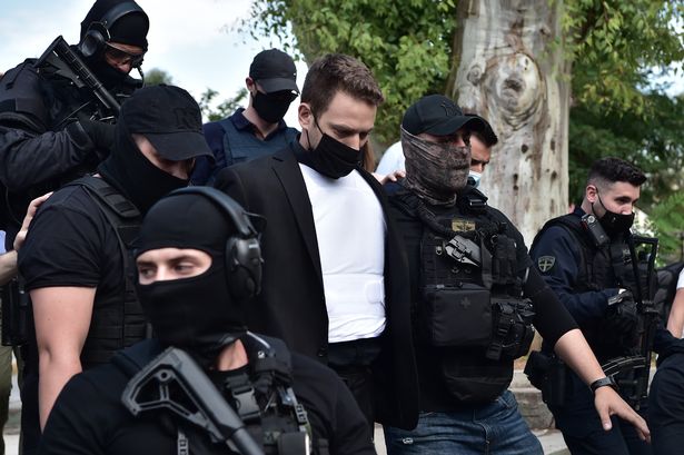 Babis Anagnostopoulos leaves the court escorted by police