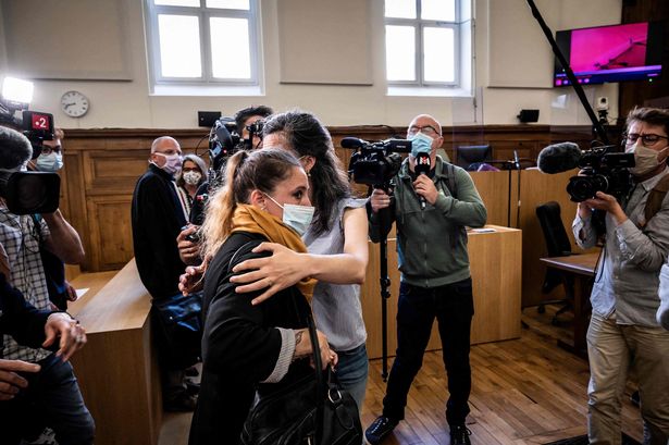 Accused Valerie Bacot (C/yellow scarf) arrives flanked by her family and surrounded by journalists at the Chalon-sur-Saone Courthouse, Chalon-sur-Saone