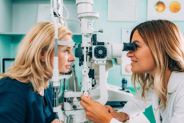 Ophthalmologist examining patient with slit lamp