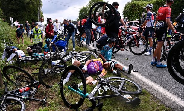 A cycling spectator who caused one of the worst crashes in the history of the Tour de France faces up to a year in prison after running away from the massive pile-up.
The female fan reached out into the road with a placard aimed at the TV cameras during the first stage of this year’s world-famous racefrom Brest to Landeneau.
The spectator appeared oblivious to the danger posed as Jumbo-Visma’s Tony Martin struck the sign and hit the deck to cause a colossal pile-up of stricken riders and broken bikes.