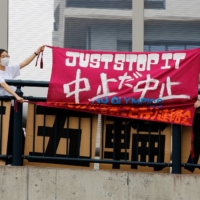 Anti-Olympics group members display banners as they stage a rally next to the village plaza of the Tokyo 2020 Olympic and Paralympic Village on Sunday. | REUTERS