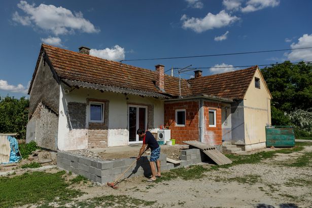 Danijel Harmnicar, owner of a house bought for 1 HRK, works in his yard in the village of Legrad