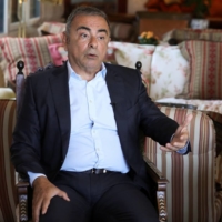 Fugitive former car executive Carlos Ghosn speaks as he sits next to his wife Carole Ghosn, during an interview in Beirut on Monday. | REUTERS