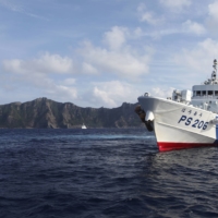 A Japan Coast Guard vessel sails in front of Uotsuri Island, one of the disputed Senkaku Islands, in August 2013.   | REUTERS