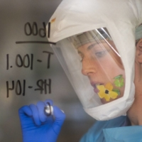 A nurse writes information on the window of a patient's room at a hospital in Salinas, California, in January. | BLOOMBERG