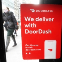 A DoorDash sign is put up on a restaurant in New York.  | REUTERS