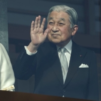 Emperor Emeritus Akihito waves to members of the public as Empress Emerita Michiko looks on during the New Year's appearance by the imperial family at the Imperial Palace in Tokyo on Jan. 2, 2020. | BLOOMBERG