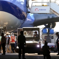 Workers transport COVID-19 vaccines at an airport in Taoyuan, Taiwan, on Friday. | REUTERS