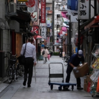 Pedestrians walk through an alley of restaurants and bars in Tokyo on May 18. G7 governments have been pumping trillions of dollars into their economies to keep them alive since the start of the pandemic in March 2020. | AFP-JIJI